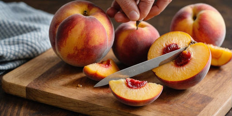 Slicing a ripe peach on a cutting board.